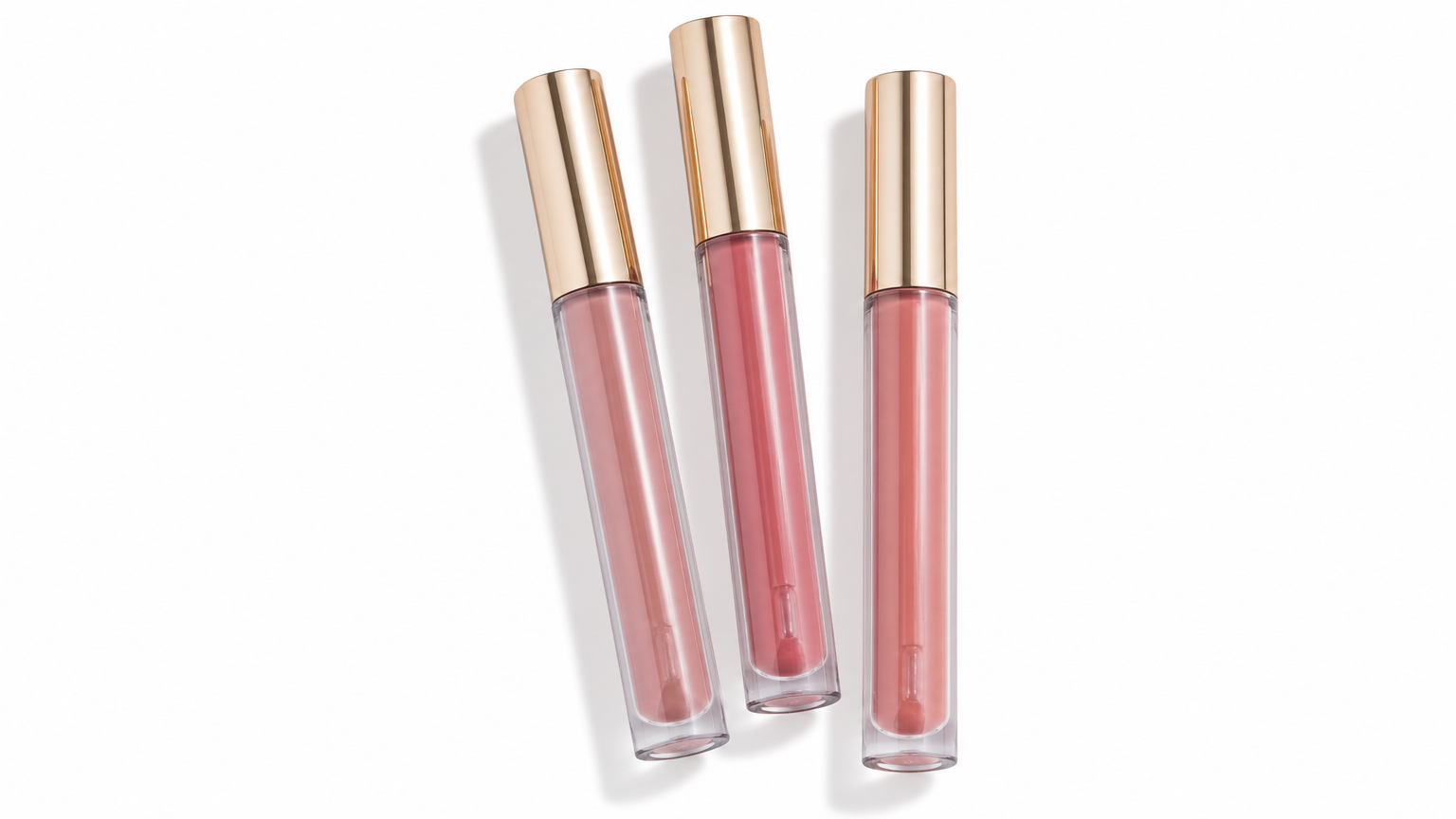 Three long clear liquid lip gloss tubes on a white background